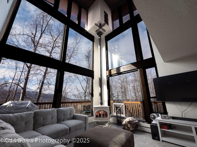 11730 Broadwater Dr, Eagle River, AK 99577 - living area featuring a towering ceiling, a wall of windows, carpet, and a wood stove