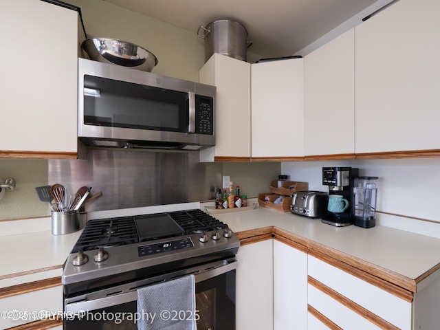 11730 Broadwater Dr, Eagle River, AK 99577 - kitchen with appliances with stainless steel finishes, light countertops, and white cabinets
