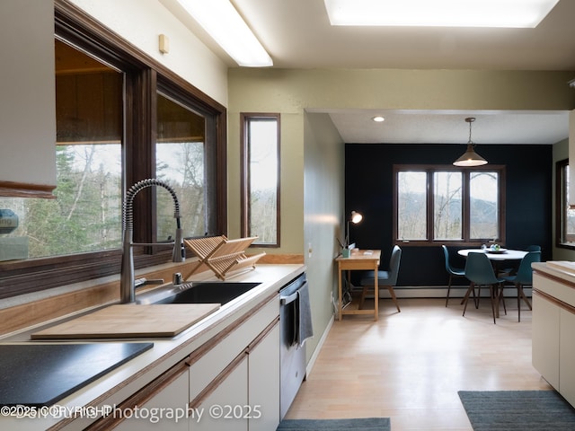 11730 Broadwater Dr, Eagle River, AK 99577 - kitchen with dishwasher, white cabinets, pendant lighting, light countertops, and light wood-style flooring