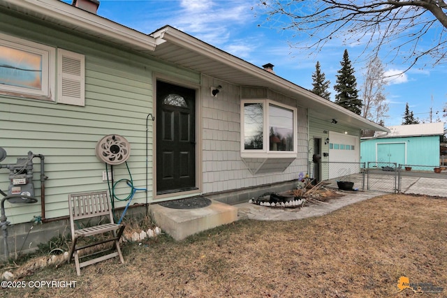 4303 E 3rd Ave, Anchorage, AK 99508 - doorway to property featuring a chimney, a gate, driveway, a garage, and fence