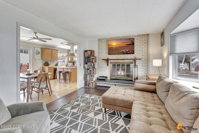 4303 E 3rd Ave, Anchorage, AK 99508 - living area with a wealth of natural light, dark wood-style flooring, a ceiling fan, and a brick fireplace