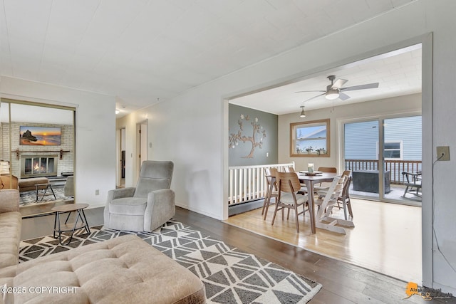 4303 E 3rd Ave, Anchorage, AK 99508 - living area with a ceiling fan, baseboard heating, hardwood / wood-style floors, and a fireplace