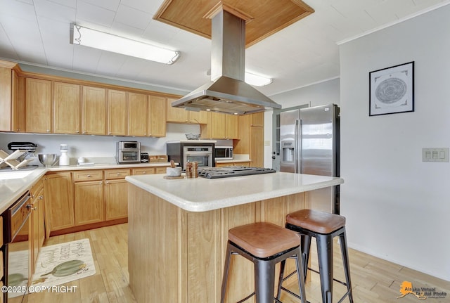 4303 E 3rd Ave, Anchorage, AK 99508 - kitchen featuring crown molding, a kitchen breakfast bar, island exhaust hood, stainless steel appliances, and light wood finished floors