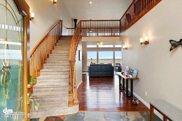 47366 Winridge Ave, Kenai, AK 99611 - staircase with a towering ceiling, wood-type flooring, and baseboards