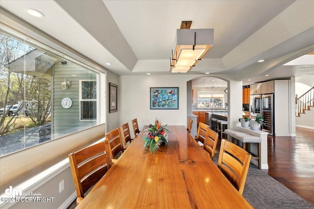 47366 Winridge Ave, Kenai, AK 99611 - dining room featuring arched walkways, wood-type flooring, stairway, recessed lighting, and a raised ceiling