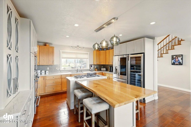 47366 Winridge Ave, Kenai, AK 99611 - kitchen featuring a sink, a breakfast bar, tasteful backsplash, dark wood finished floors, and a textured ceiling