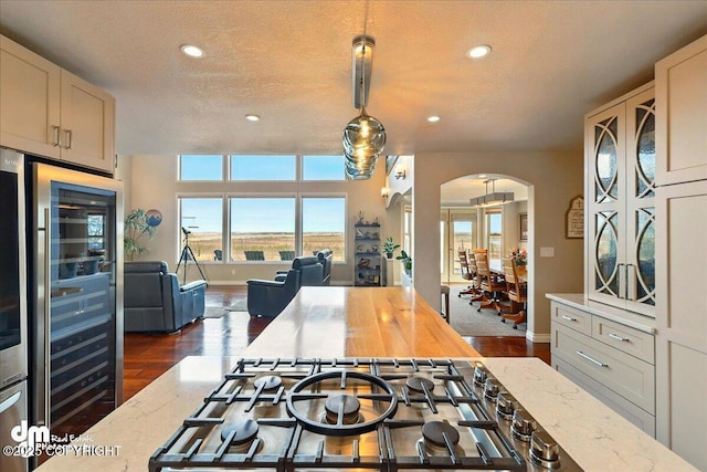 47366 Winridge Ave, Kenai, AK 99611 - kitchen with arched walkways, open floor plan, light stone counters, wine cooler, and recessed lighting