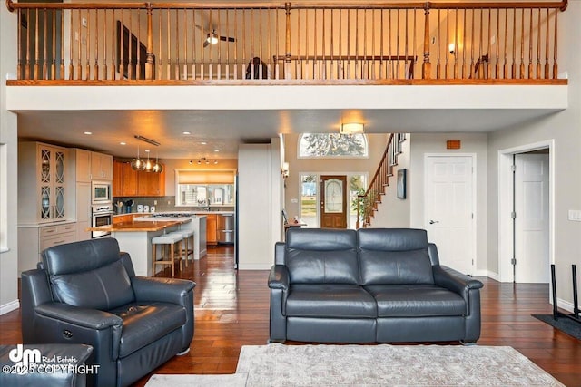 47366 Winridge Ave, Kenai, AK 99611 - living area featuring dark wood-style floors, baseboards, a high ceiling, and stairs