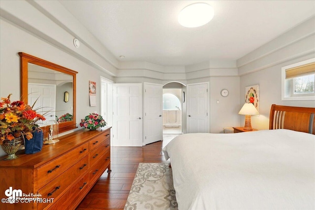 47366 Winridge Ave, Kenai, AK 99611 - bedroom featuring dark wood-style floors, arched walkways, and connected bathroom