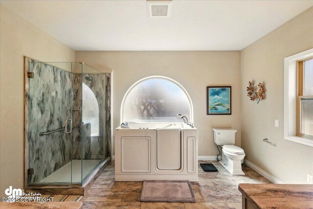 47366 Winridge Ave, Kenai, AK 99611 - full bathroom featuring a bath, a stall shower, toilet, and baseboards