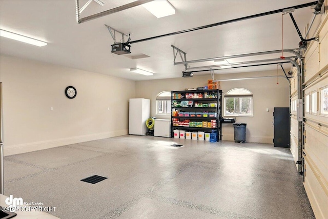 47366 Winridge Ave, Kenai, AK 99611 - garage with a garage door opener, freestanding refrigerator, and baseboards