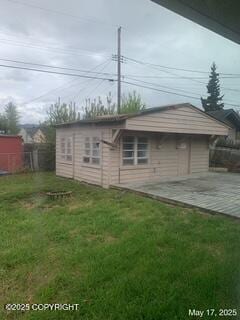 1415 Twining Dr, Anchorage, AK 99504 - rear view of house featuring a lawn and an outdoor structure
