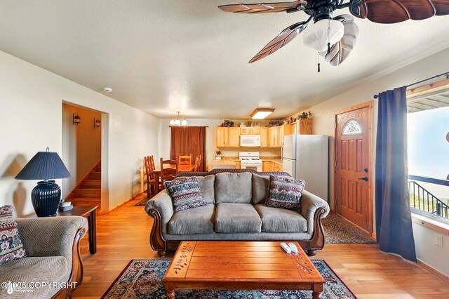 22045 Becharof Cir, Kasilof, AK 99610 - living room with light wood-style flooring, ceiling fan, stairway, a chandelier, and baseboards