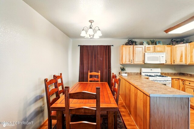 22045 Becharof Cir, Kasilof, AK 99610 - dining area featuring a chandelier, light wood-style floors, and baseboards