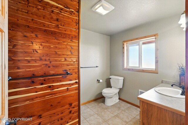 22045 Becharof Cir, Kasilof, AK 99610 - bathroom with baseboards, vanity, toilet, and tile patterned flooring