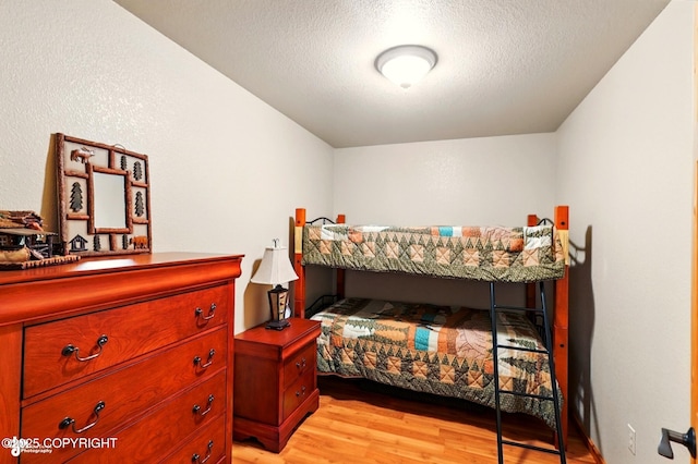 22045 Becharof Cir, Kasilof, AK 99610 - bedroom featuring light wood-style floors and a textured ceiling