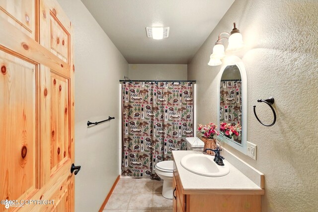 22045 Becharof Cir, Kasilof, AK 99610 - bathroom featuring vanity, tile patterned floors, toilet, a shower with shower curtain, and a textured wall