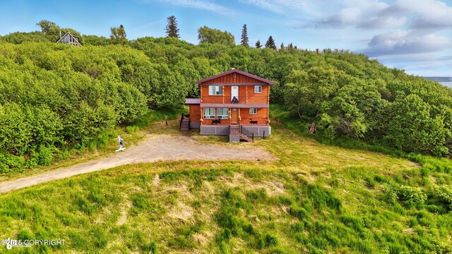 22045 Becharof Cir, Kasilof, AK 99610 - rear view of house featuring a wooded view, covered porch, and driveway