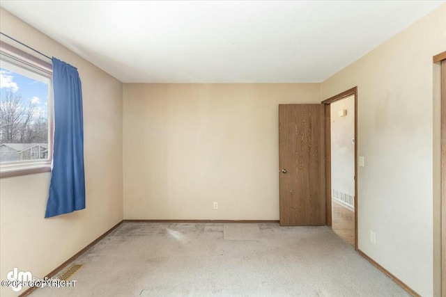 spare room featuring visible vents, carpet flooring, and baseboards