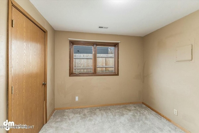 unfurnished bedroom with a closet, carpet floors, visible vents, and baseboards