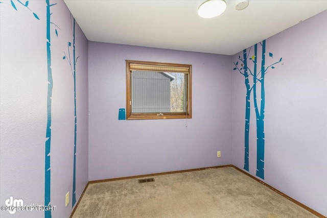 carpeted empty room featuring visible vents and baseboards
