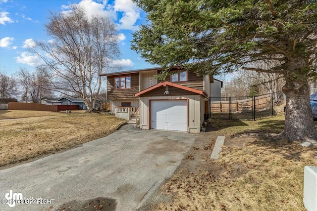 view of front of property with an attached garage, driveway, and fence