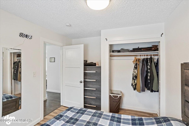 3936 W 88th Ave, Anchorage, AK 99502 - bedroom with a closet, baseboards, wood finished floors, and a textured ceiling