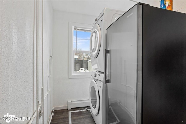 3936 W 88th Ave, Anchorage, AK 99502 - laundry room with baseboards, dark wood-style flooring, stacked washer and clothes dryer, laundry area, and a baseboard heating unit