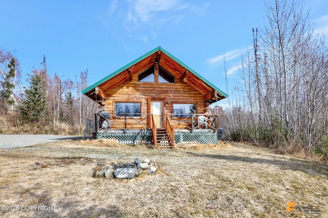 log cabin featuring a wooden deck and log siding