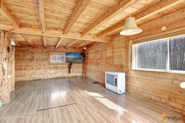 additional living space featuring beamed ceiling, wooden ceiling, wood finished floors, wooden walls, and heating unit