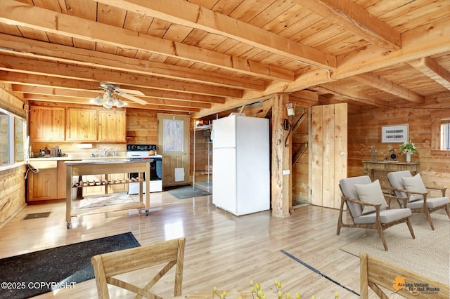 interior space with a ceiling fan, wooden walls, wood ceiling, light wood-style flooring, and beam ceiling