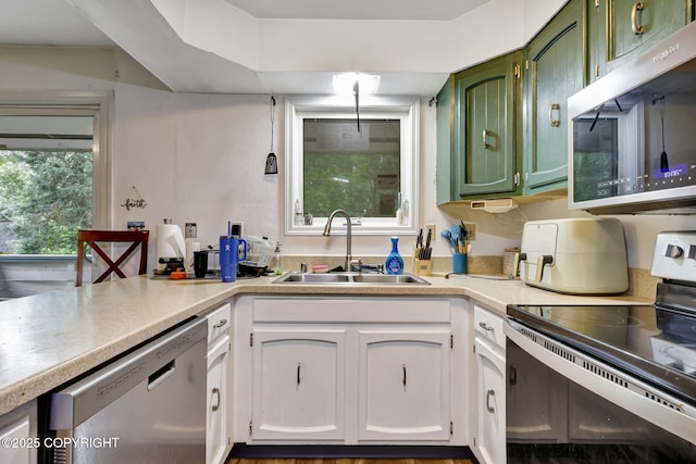3550 Kachemak Cir, Anchorage, AK 99515 - kitchen featuring stainless steel appliances, a sink, light countertops, green cabinets, and white cabinetry