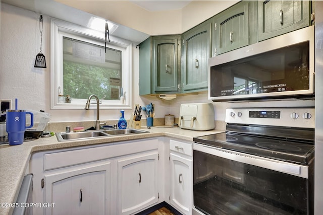 3550 Kachemak Cir, Anchorage, AK 99515 - kitchen with appliances with stainless steel finishes, green cabinetry, a sink, light countertops, and a textured wall