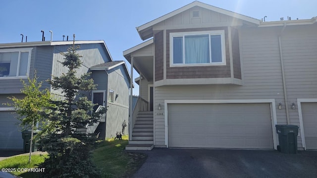 6244 Ophir Dr, Anchorage, AK 99504 - view of front of house featuring a garage, driveway, stairs, and board and batten siding