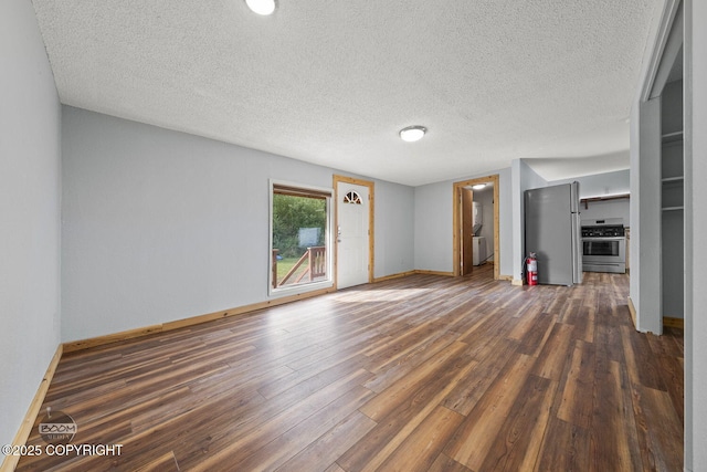 8153 Stewart Mountain Dr, Eagle River, AK 99577 - unfurnished living room featuring dark wood-type flooring, a textured ceiling, and baseboards