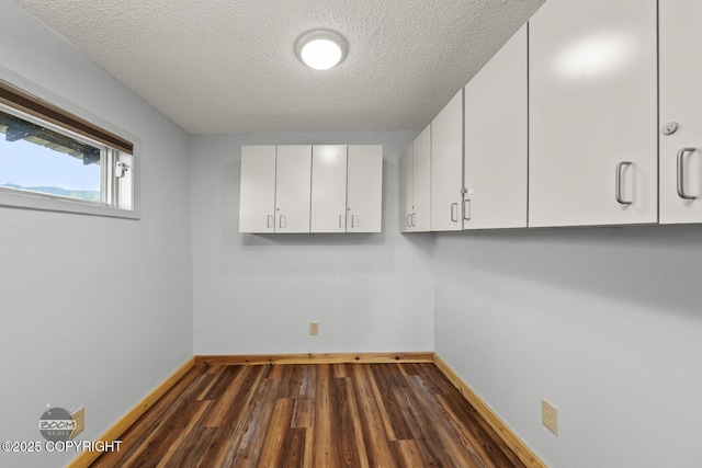 8153 Stewart Mountain Dr, Eagle River, AK 99577 - laundry room featuring dark wood-type flooring, baseboards, and a textured ceiling