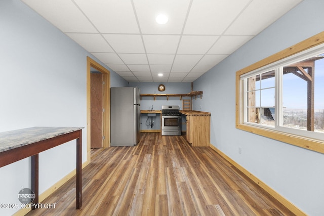 8153 Stewart Mountain Dr, Eagle River, AK 99577 - kitchen with appliances with stainless steel finishes, wood finished floors, a paneled ceiling, baseboards, and a sink
