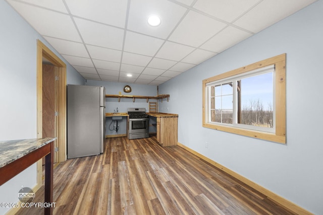 8153 Stewart Mountain Dr, Eagle River, AK 99577 - kitchen with appliances with stainless steel finishes, a drop ceiling, wood finished floors, baseboards, and a sink
