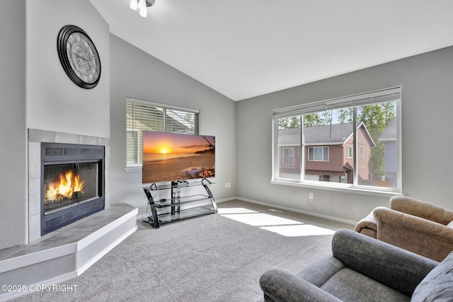 2460 Lochenshire Pl Unit 21, Anchorage, AK 99504 - living area with carpet flooring, a tiled fireplace, lofted ceiling, and baseboards