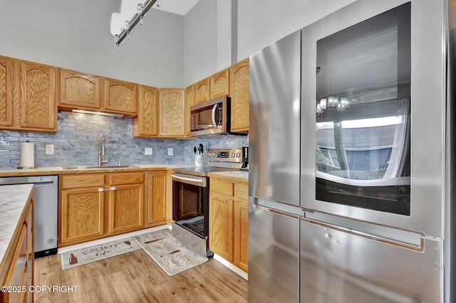 2460 Lochenshire Pl Unit 21, Anchorage, AK 99504 - kitchen with appliances with stainless steel finishes, a sink, light countertops, and light wood-style floors