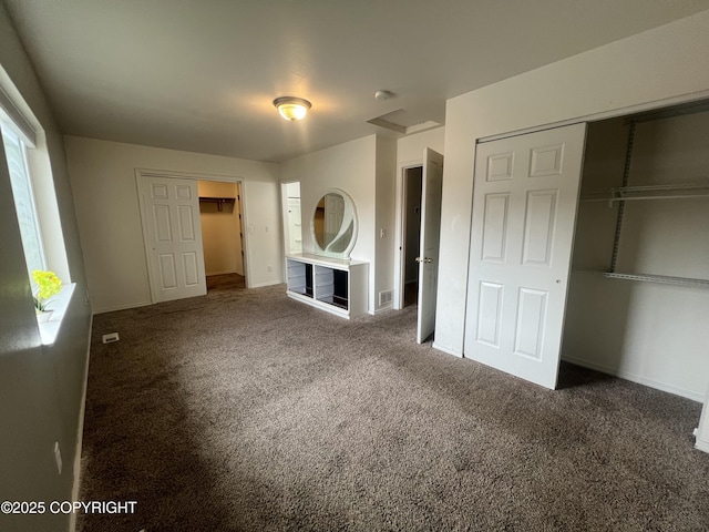 unfurnished bedroom with a closet, visible vents, carpet floors, and baseboards