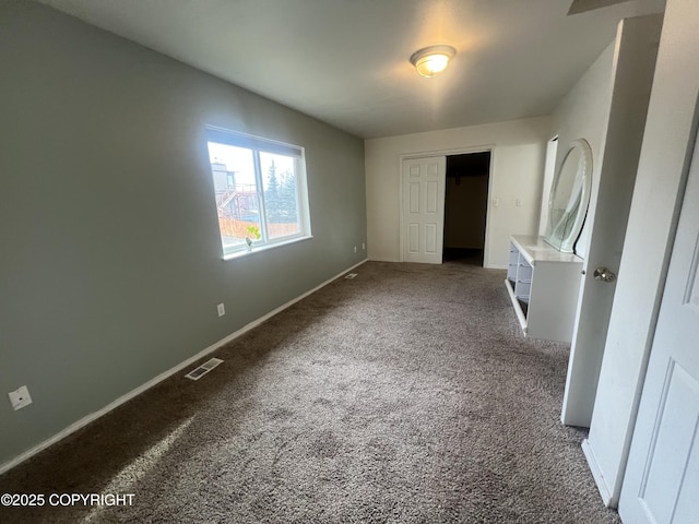 unfurnished bedroom featuring carpet flooring, visible vents, and baseboards