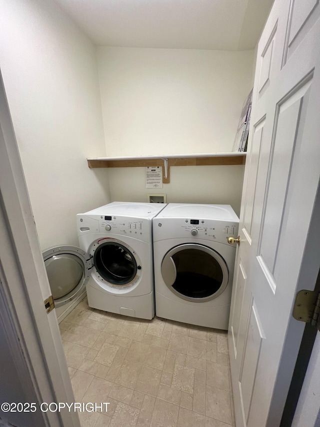washroom with washing machine and clothes dryer and laundry area