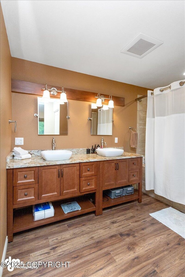 13598 N Willow Dr, Willow, AK 99688 - bathroom with a sink, visible vents, double vanity, and wood finished floors