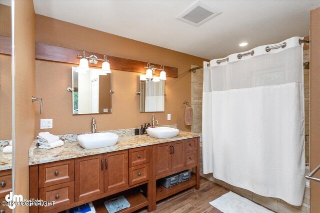 13598 N Willow Dr, Willow, AK 99688 - full bathroom featuring wood finished floors, double vanity, a sink, and visible vents