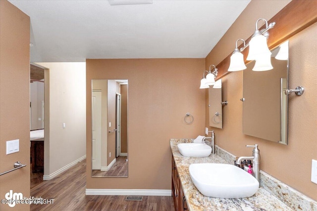 13598 N Willow Dr, Willow, AK 99688 - bathroom with wood finished floors, double vanity, a sink, and baseboards