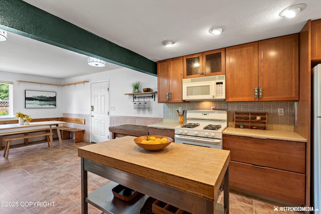 1602 Richardson Dr, Anchorage, AK 99504 - kitchen with white appliances, light countertops, brown cabinetry, and a wainscoted wall