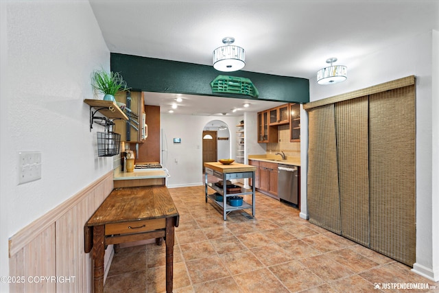 1602 Richardson Dr, Anchorage, AK 99504 - kitchen with arched walkways, stainless steel dishwasher, light countertops, glass insert cabinets, and open shelves