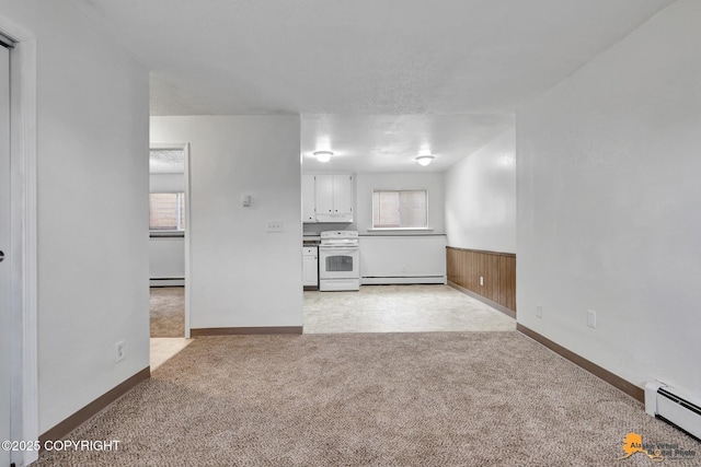 525 E 14th Ave, Anchorage, AK 99501 - unfurnished living room with light carpet, a baseboard heating unit, and a wainscoted wall