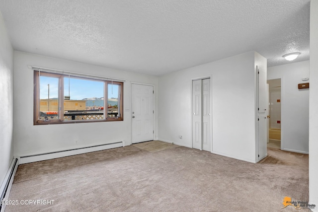 525 E 14th Ave, Anchorage, AK 99501 - unfurnished bedroom with a textured ceiling, carpet, a baseboard heating unit, and a closet